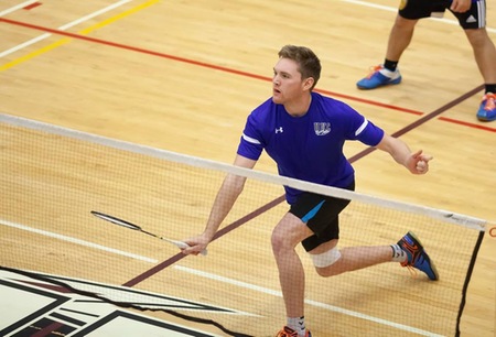 Badminton player Sam White lunges for the shuttle in a doubles match.