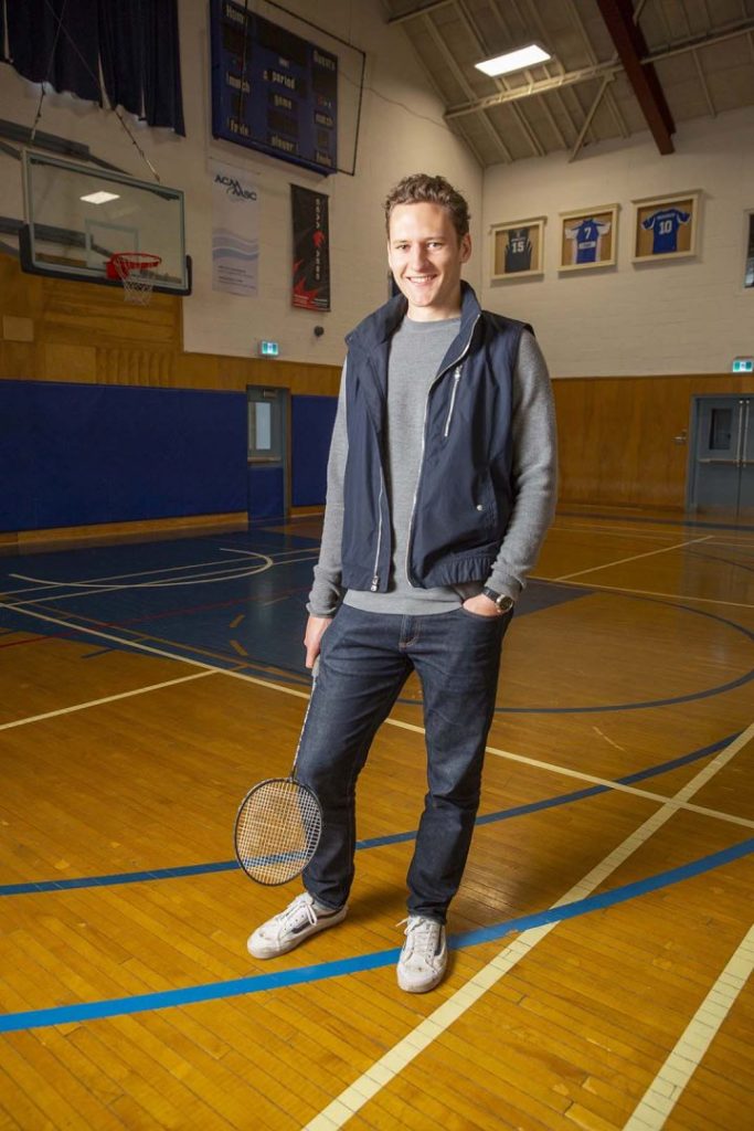 Benn Van Ryn in the gymnasium holding a badminton racquet.