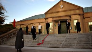 Students perform a play outdoors on the library steps