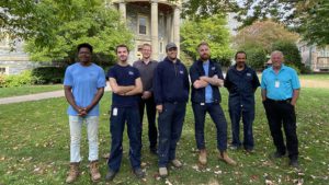 Facilities team stand together on King's Quad