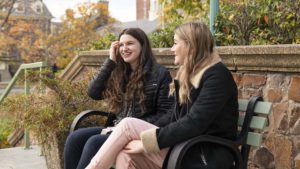 Two students talk on a bench on King's campus
