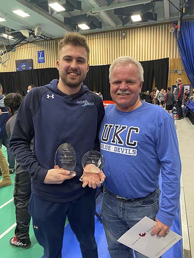 Bryce Mason stands with his father after being awarded CCAA Men's Badminton Player of the Year.