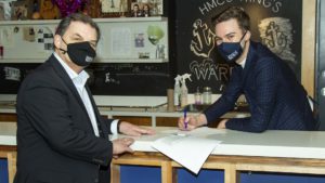 President William Lahey and Nick Harris sign an agreement in the Wardroom