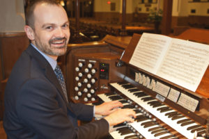Neil Cockburn sitting at organ keyboard