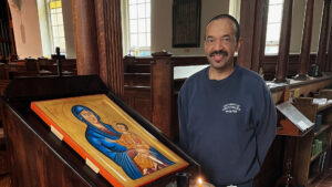 Rodney Parsons next to the wooden stand that holds the new chapel icon