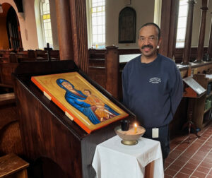 Rodney Parsons next to the wooden stand that holds the new chapel icon