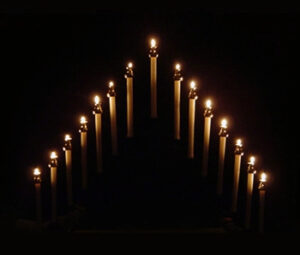 Tenebrae candles lit and forming a pyramid shape - shot on black background