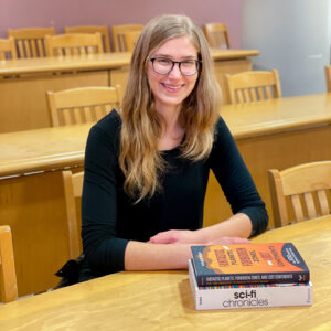 Emma Brouwer sitting at table with books in front of her