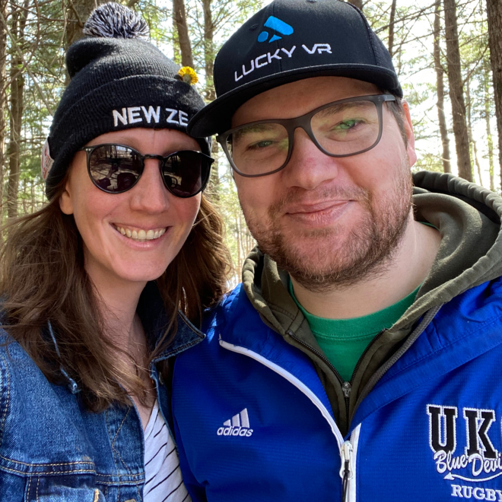 Matt Feir and Alyssa Feir standing in woods smiling to camera