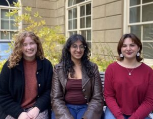 three people sitting on bench in willwerth garden in fall 2025