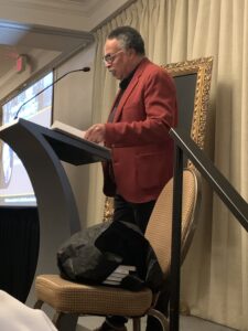 Dr. George Elliott Clarke standing at podium delivering keynote address to the USS Conference, October 2023