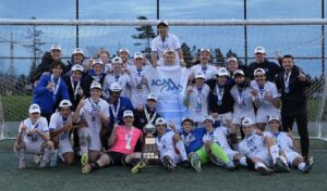 King's men's soccer team gather for group shot wearing their medals after winning the ACAA championship October 2023