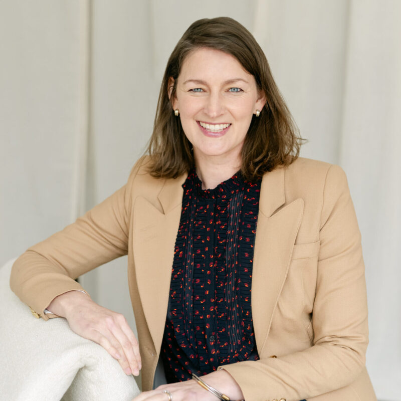 Jane Baldwin sitting on a chair smiling for the camera.