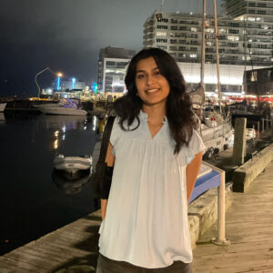 Ritu standing on the boardwalk in Halifax at night.
