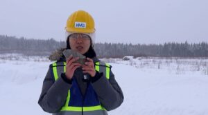 Lu Fan holding a rock in winter wearing yellow construction helmet