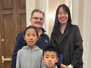 Lu Fan stands with Bill Lahey and her two children in front of her