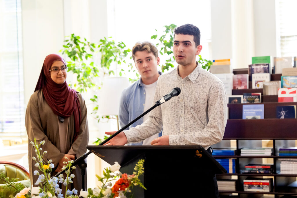 three students stand behind mike at King's Library 