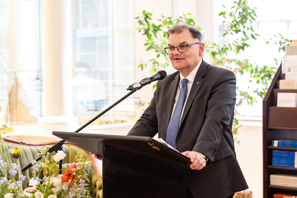 Pres. Lahey stands at podium with microphone in King's Library during his farewell.